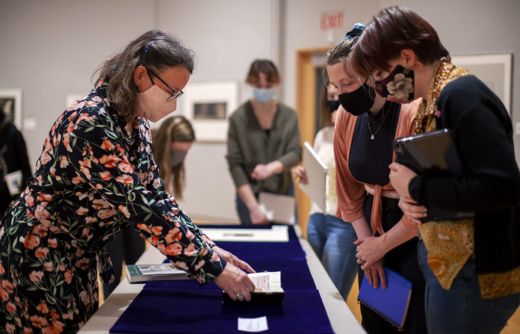 Professor showing two students a historical document 