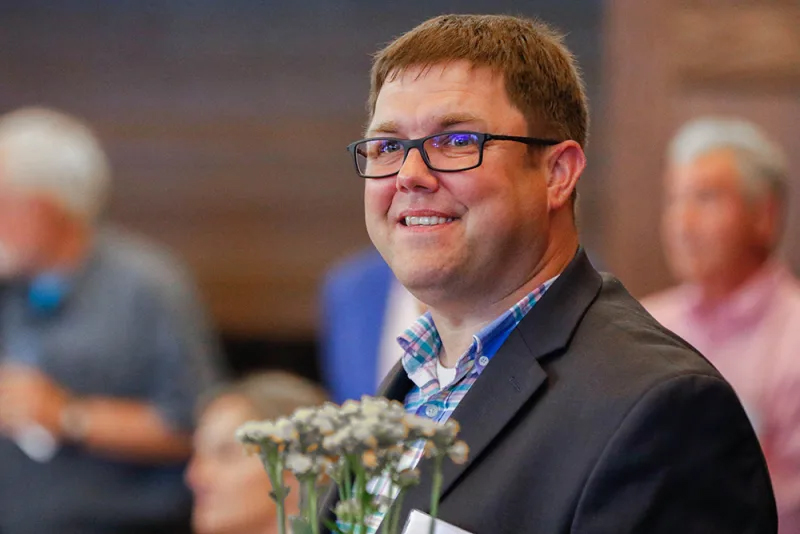 Will Piper holds flowers at an event. 