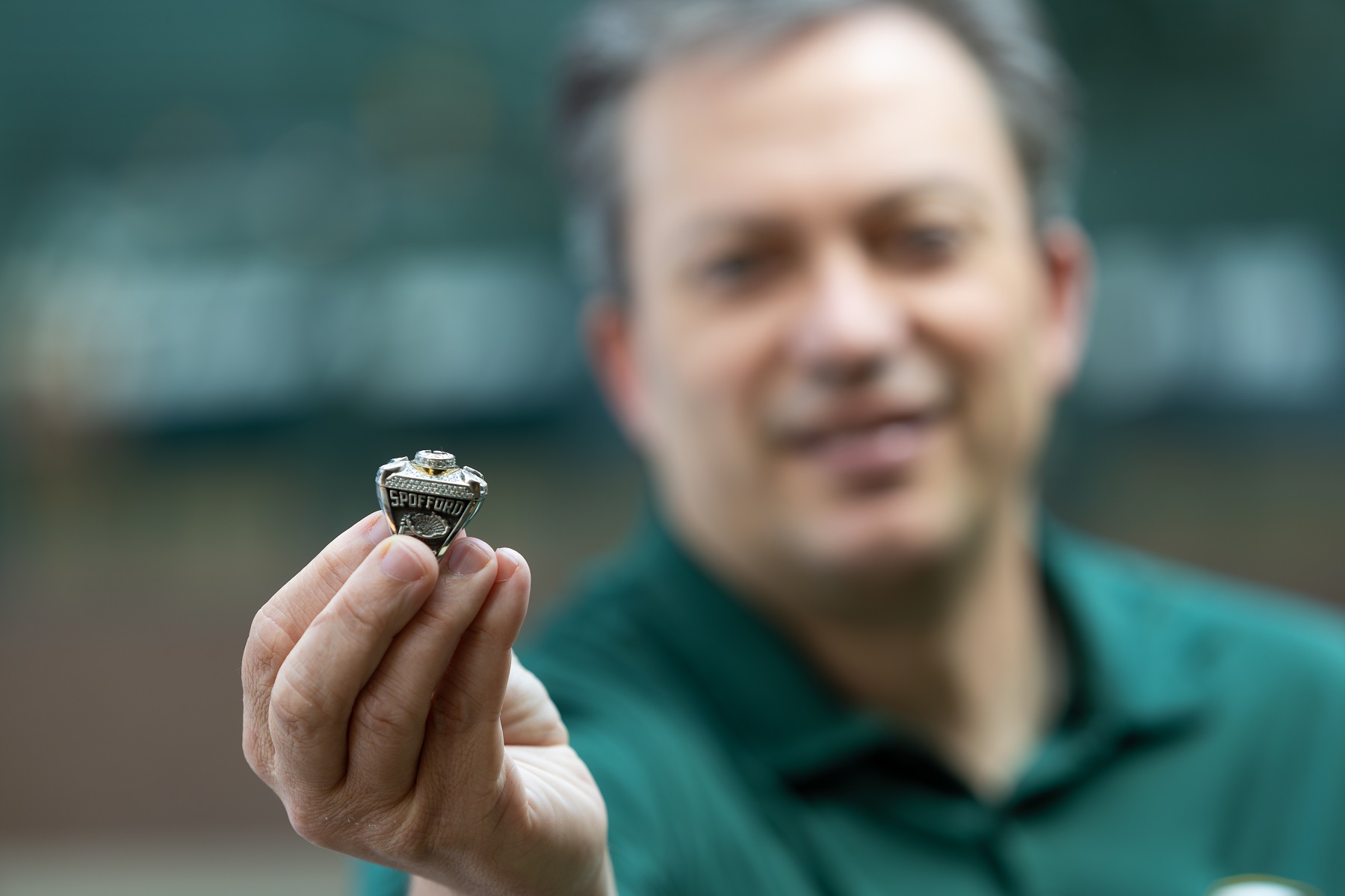 Mike Spofford shows his Super Bowl ring while standing in Lambeau Field.