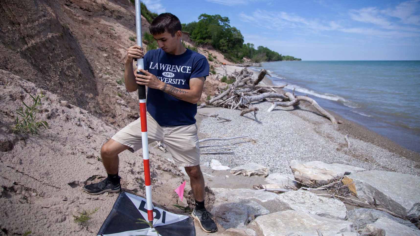 Student conducting UAV research on shore of Lake Michigan