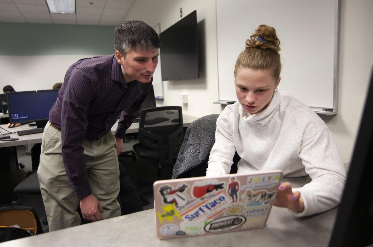 Andrew Sage, assistant professor of statistics, works with Erin Lengel, a computer science degree student, in a Data-Scientific Programming class during Winter Term. 