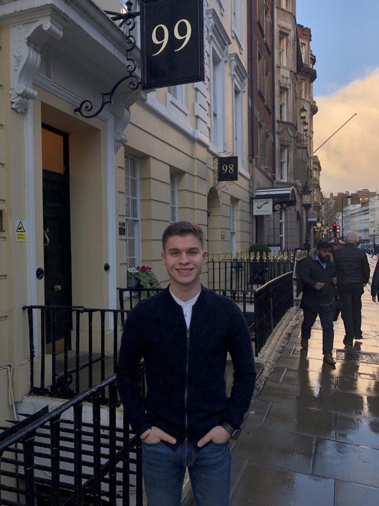 Andrea Arivella stands with his hands in his pockets on a UK sidewalk.