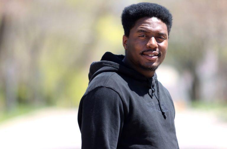 Oryan Brown, wearing a black hoodie, smiles at the camera.
