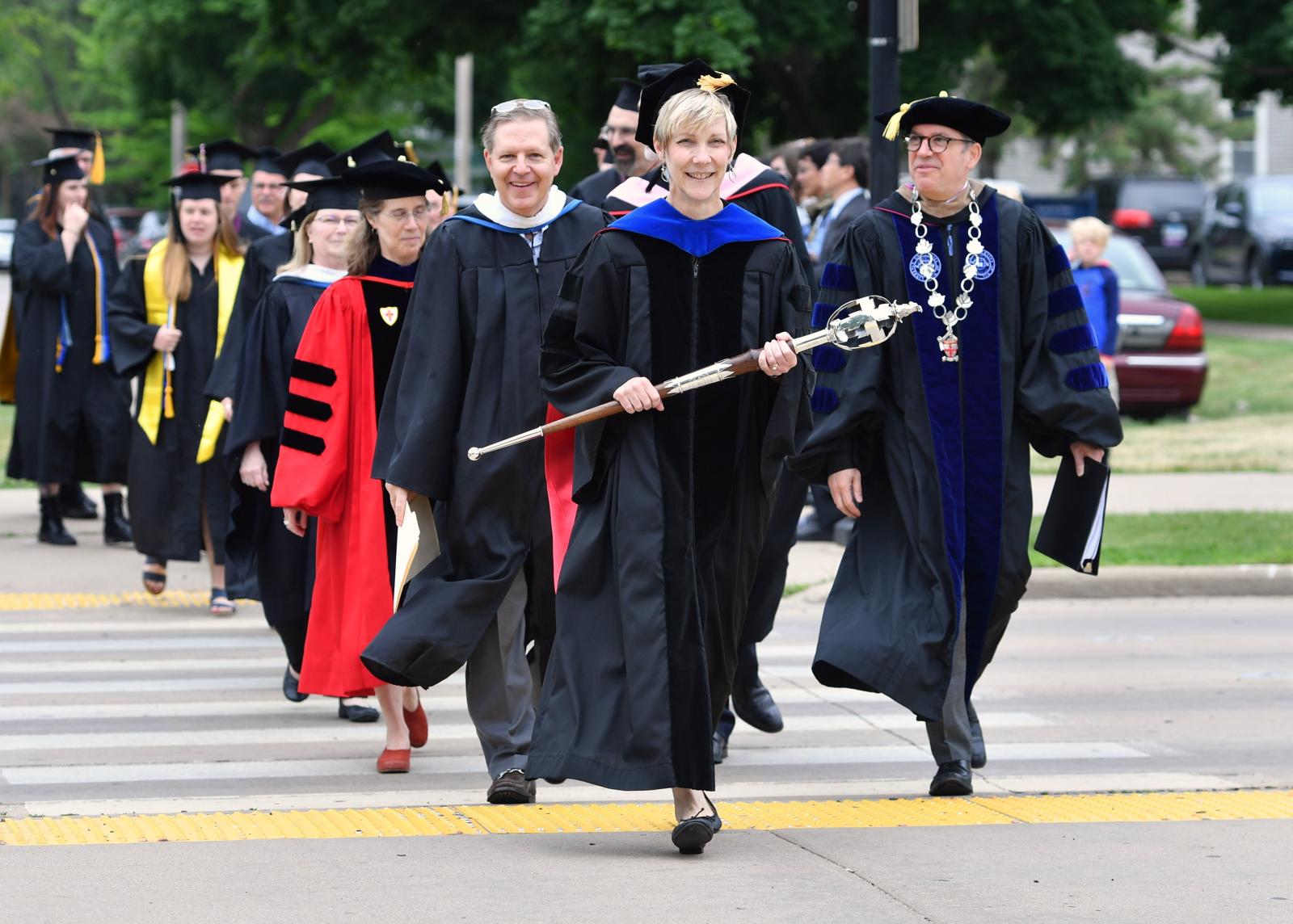 March across College Avenue to Main Hall green, led by Faculty Marshal Kathy Privatt and President Mark Burstein (right), part of Lawrence University’s Commencement