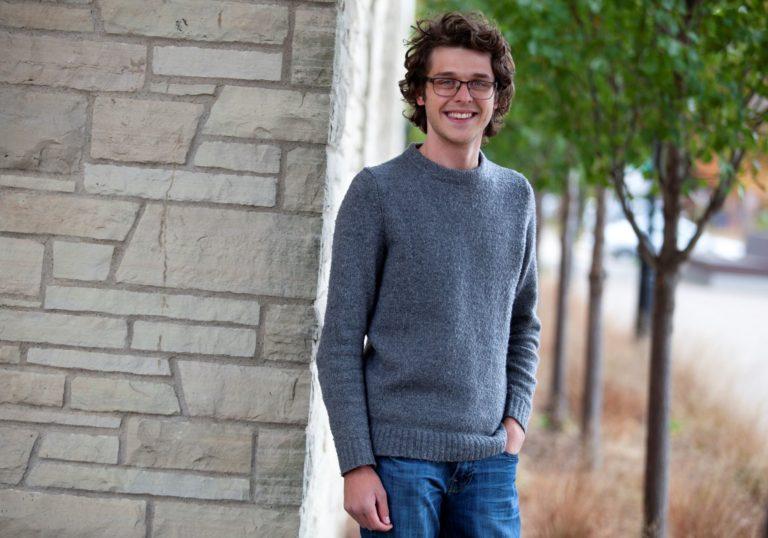 Jonathan Hogan, wearing a grey sweater, smiles at the camera.