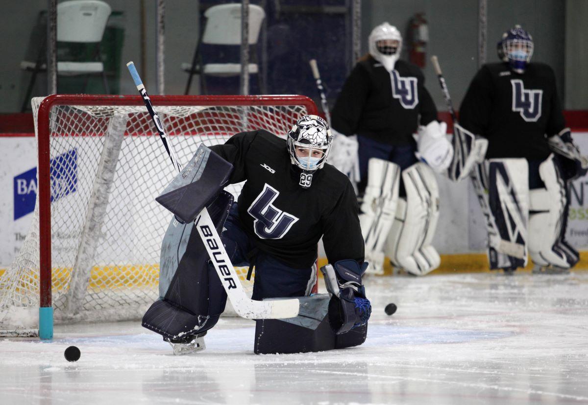 The goalie of women's Hockey Team preventing the hockey puck from entering the net