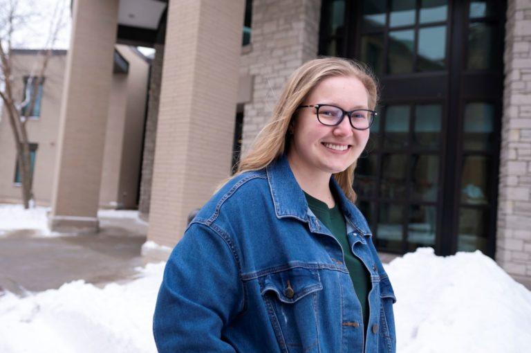 Molly Ruffing, wearing a jean jacket, smiles at the camera.