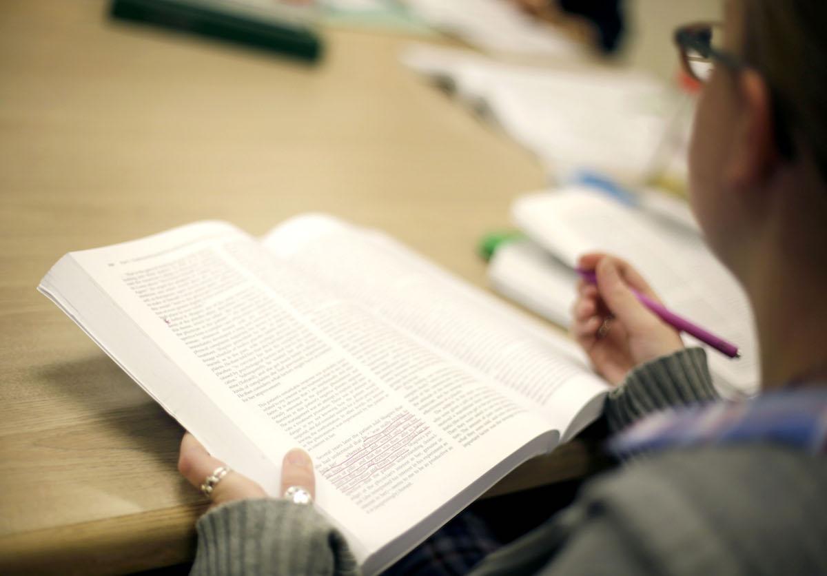 Student highlighting their textbook