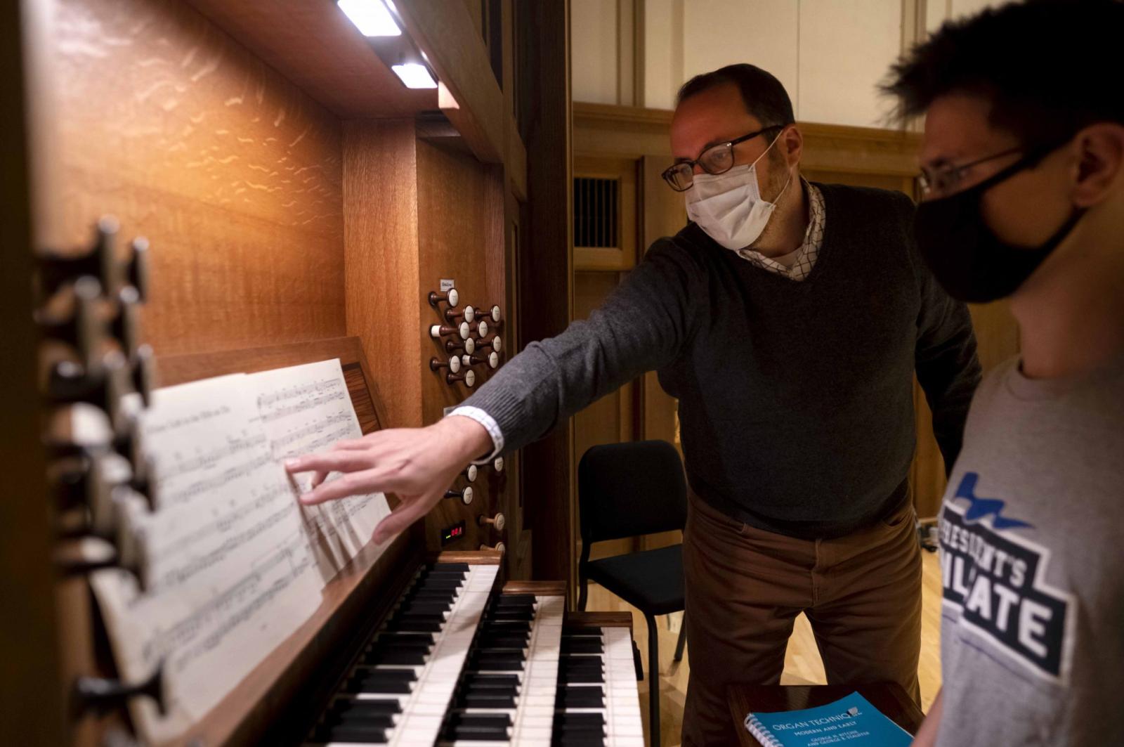 The University organist and lecturer in music works with organ student at the organ in Memorial Chapel.