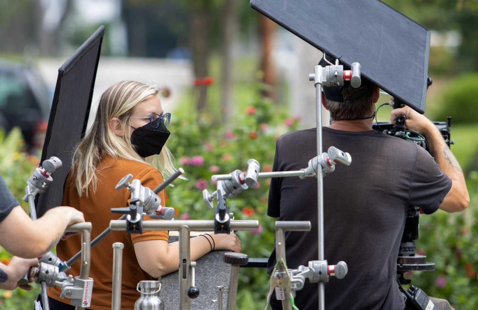 Molly Preston '10 next to a cameraman, surrounded by light stands.