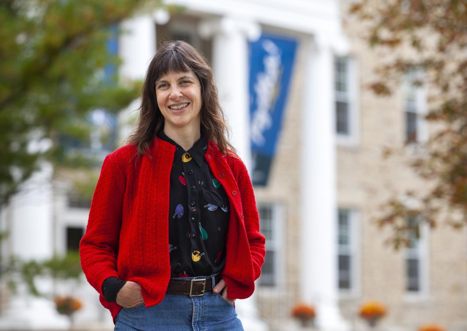 Melissa Range, wearing a red jacket, stands in front of Main Hall.