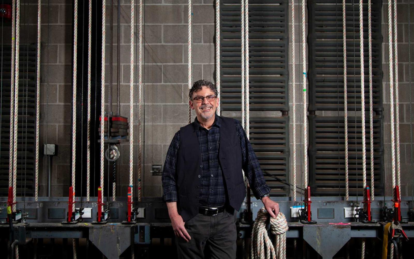 Timothy X. Troy stands back stage in Stansbury Theater.