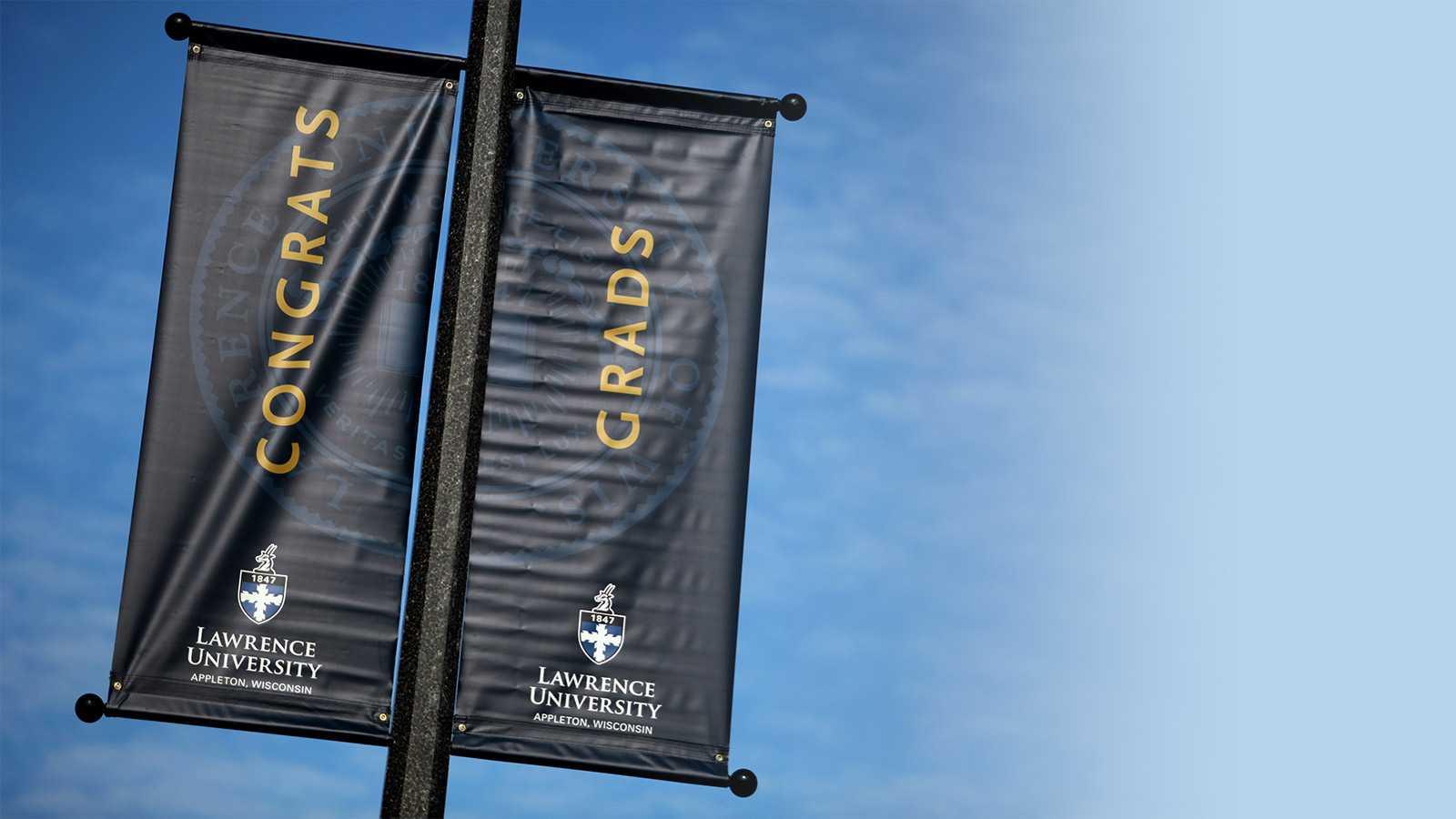 Congrats Grads banner hanging on a light pole along College Avenue.