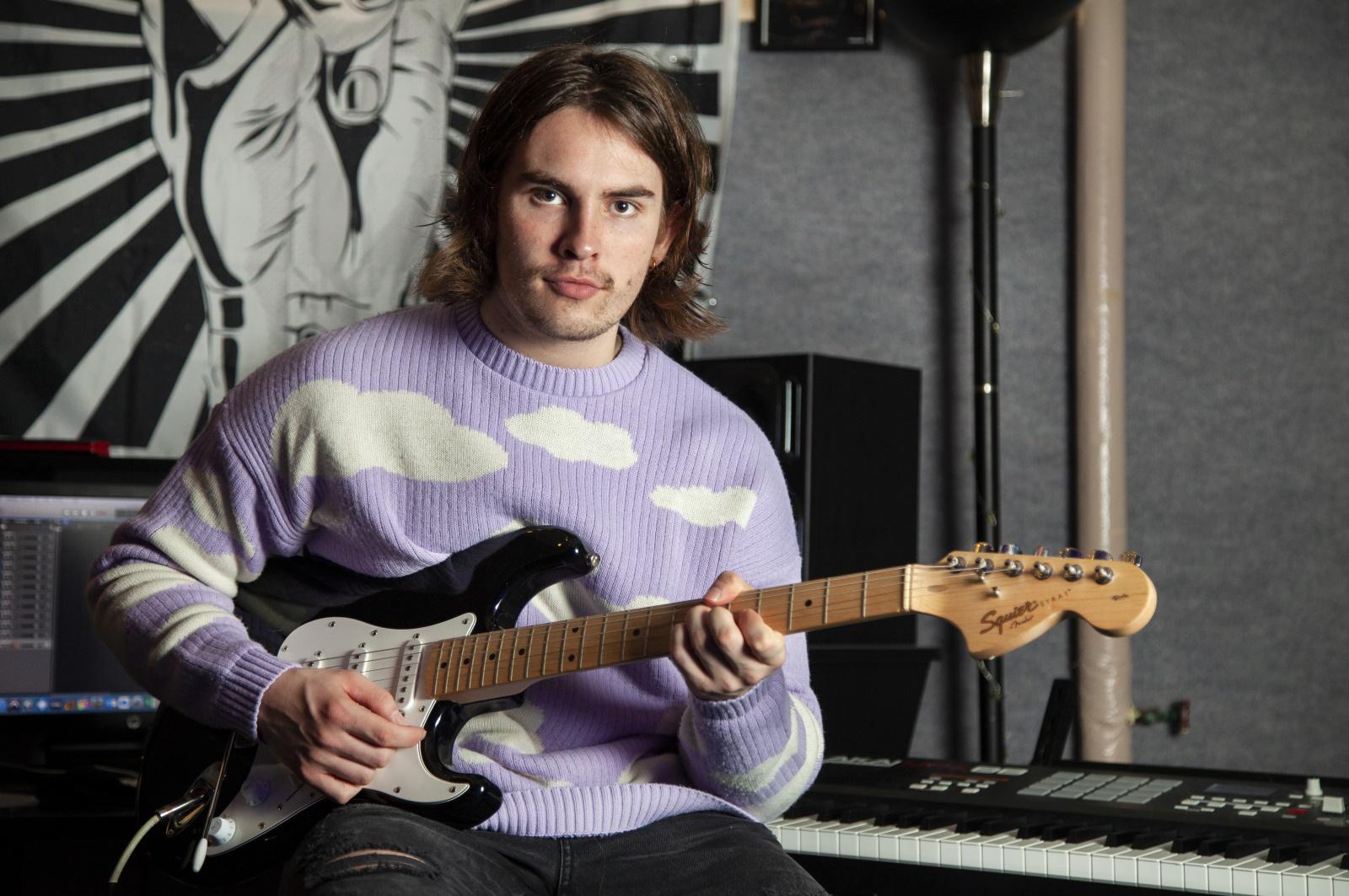 Michael Murphy poses for a photo with his guitar in SOL Studios.