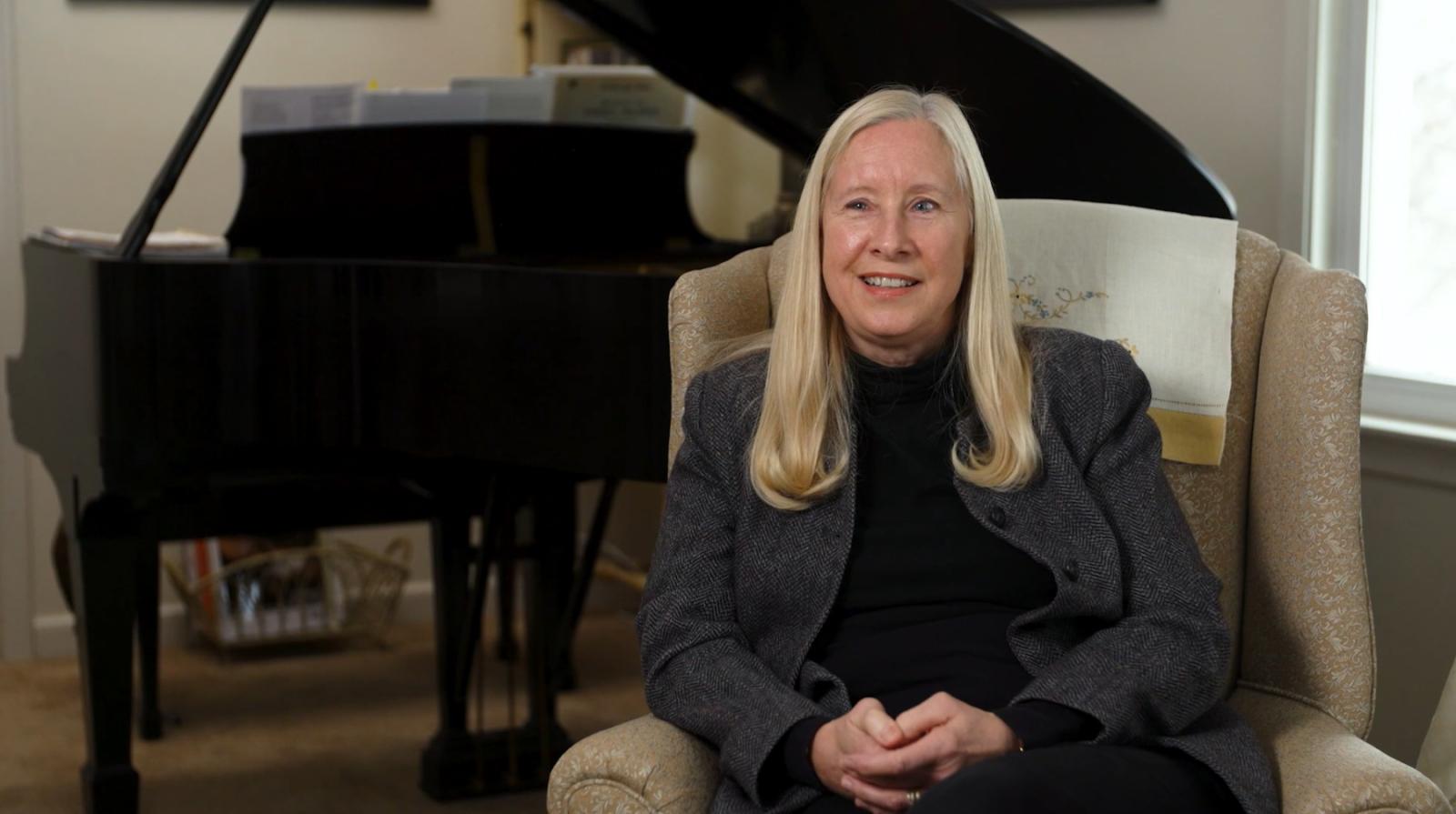Martha Helen Schmidt sits in front of a piano.