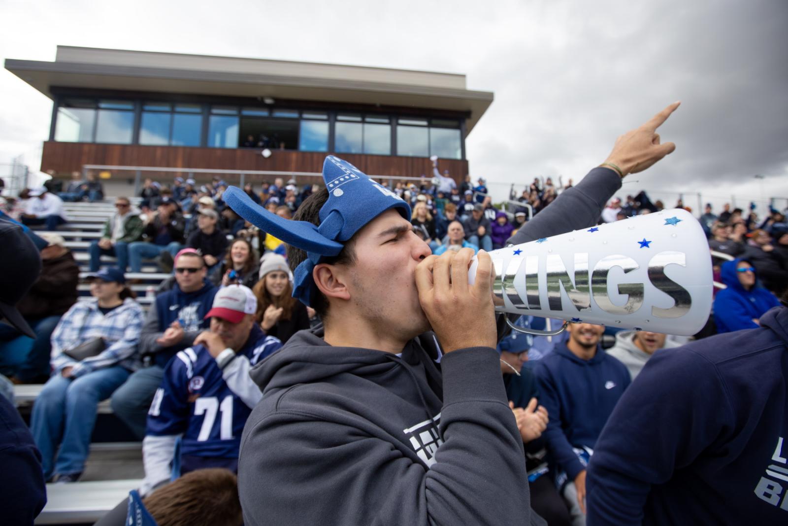 Nicolas Manzanera, a sophomore, cheers on the football team during Blue & White Homecoming Weekend at Banta Bowl.