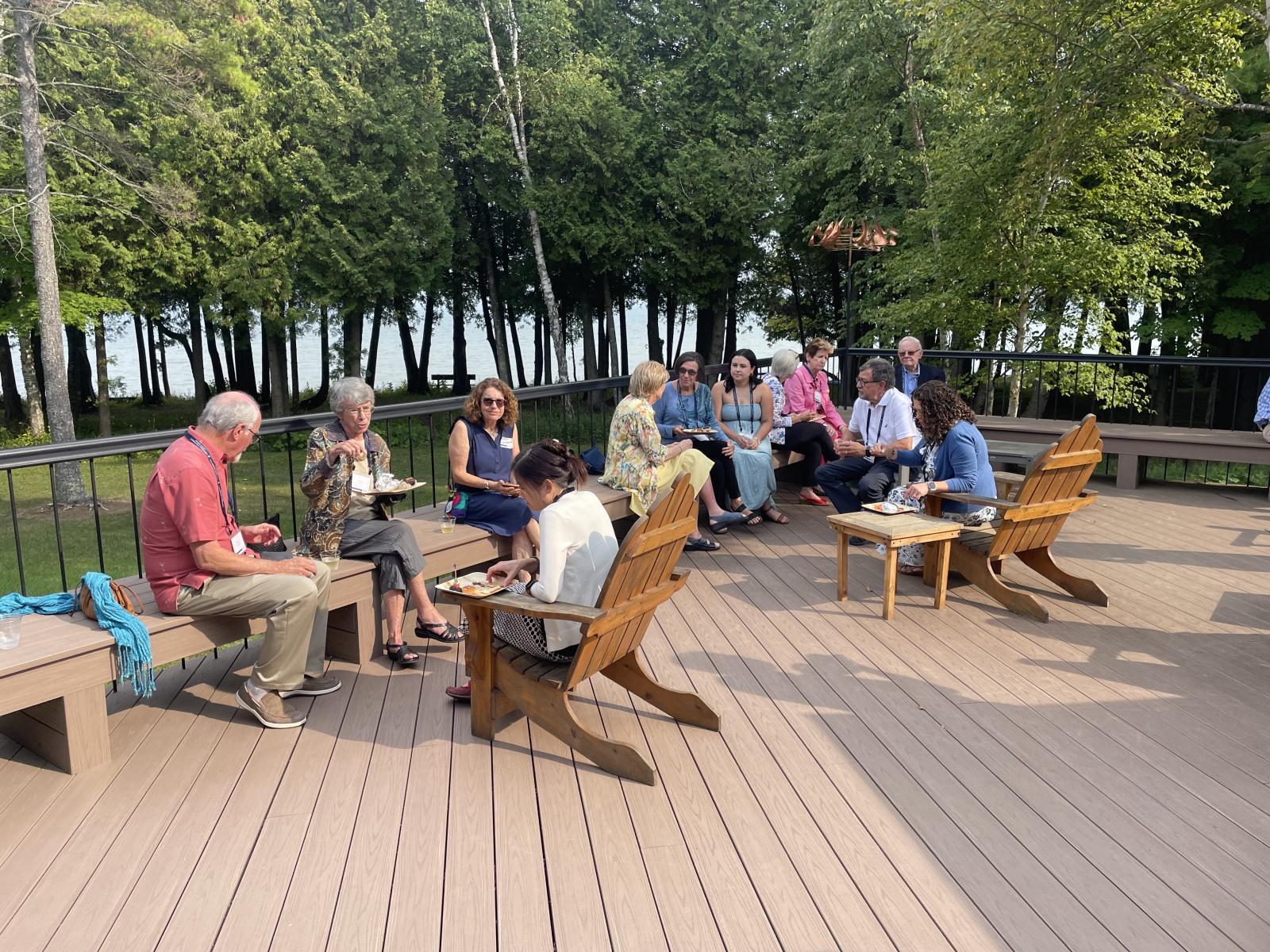 a group of people eat outside on a deck