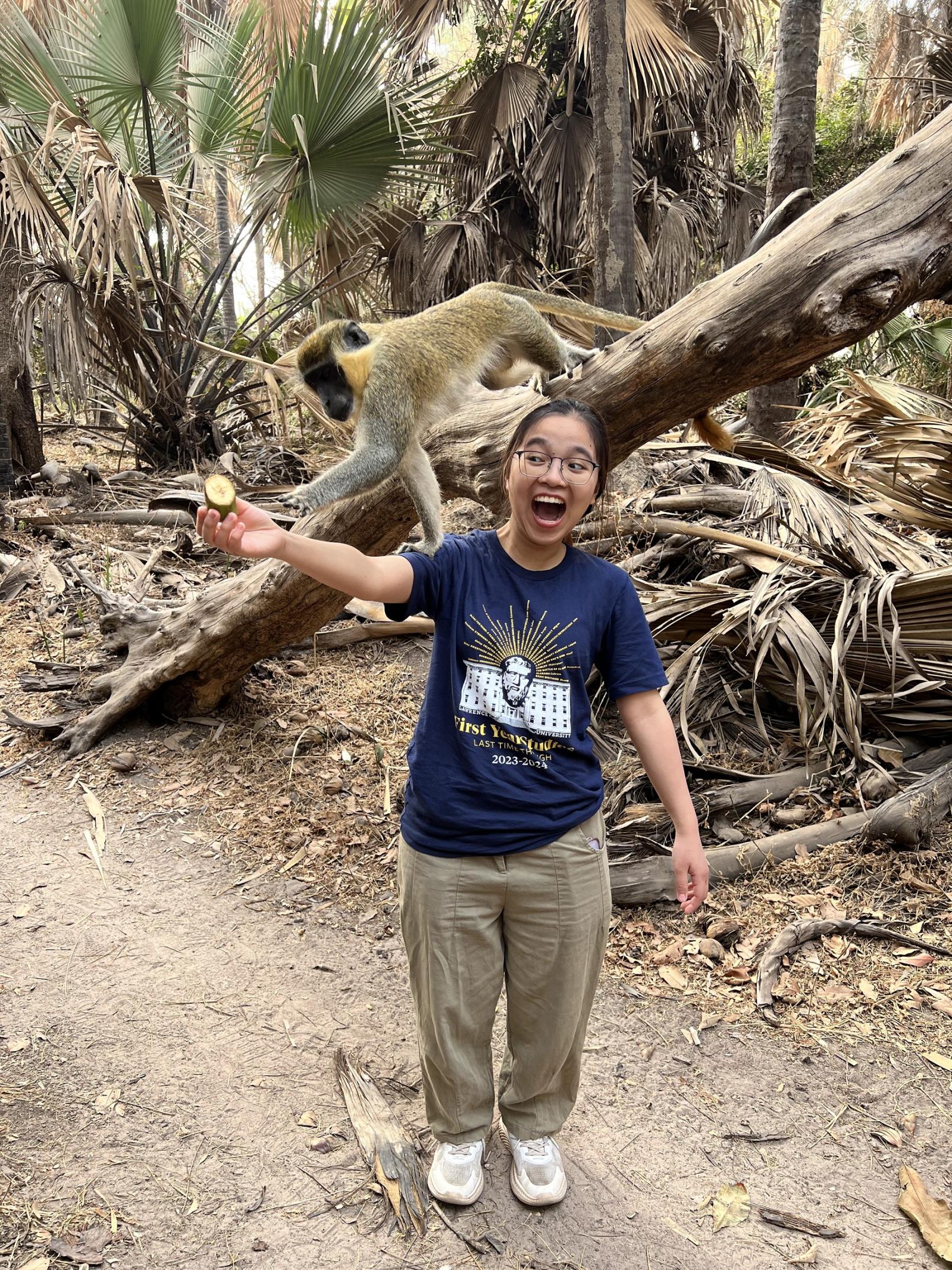 Quynh Anh Cao Le laughs as she feeds a monkey at Bijilo Forest Park, a national park often known as Monkey Park.
