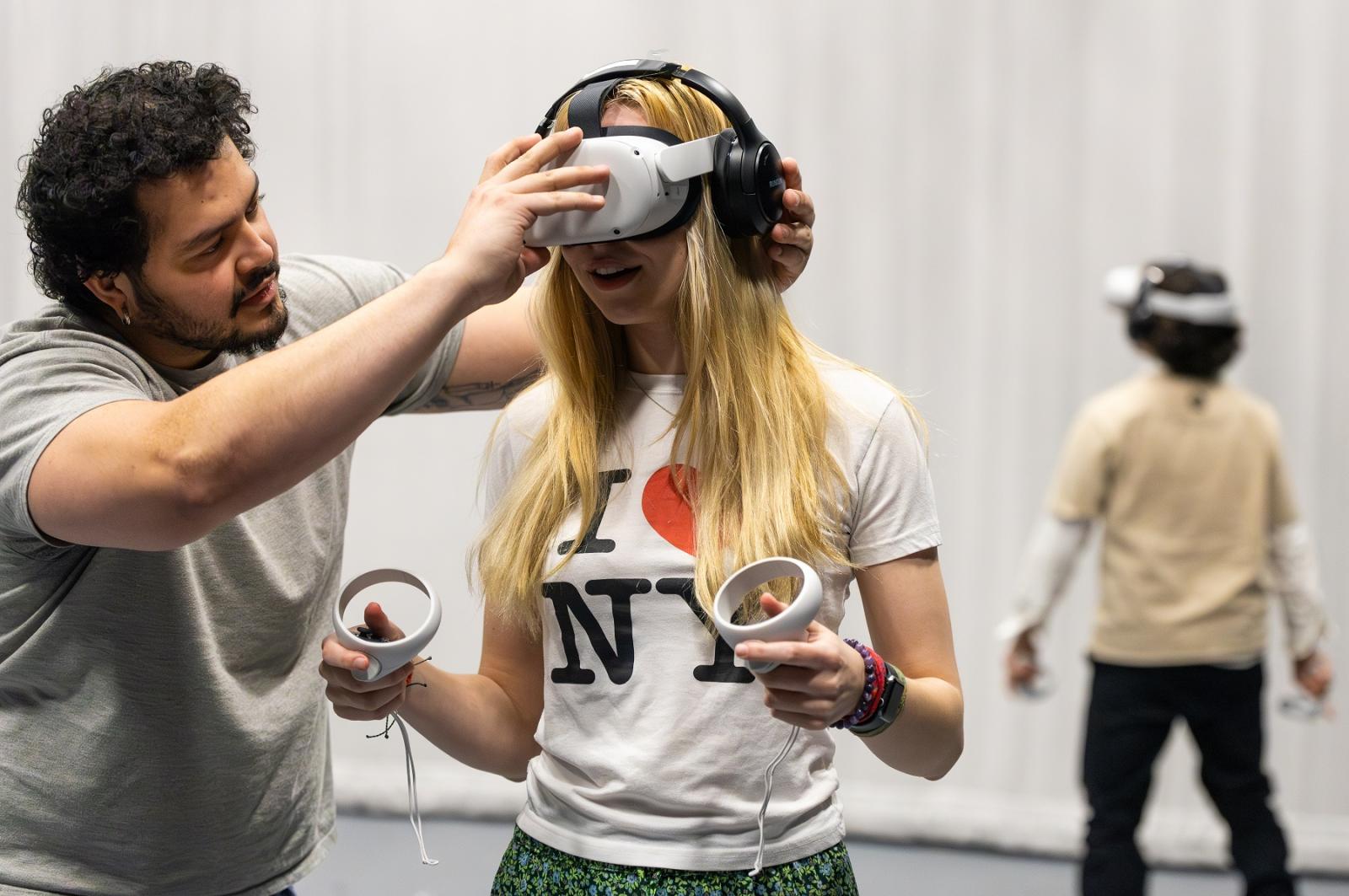 Jose Lozano works with Annika Urness, a sophomore, to set up a virtual reality multiplayer game.