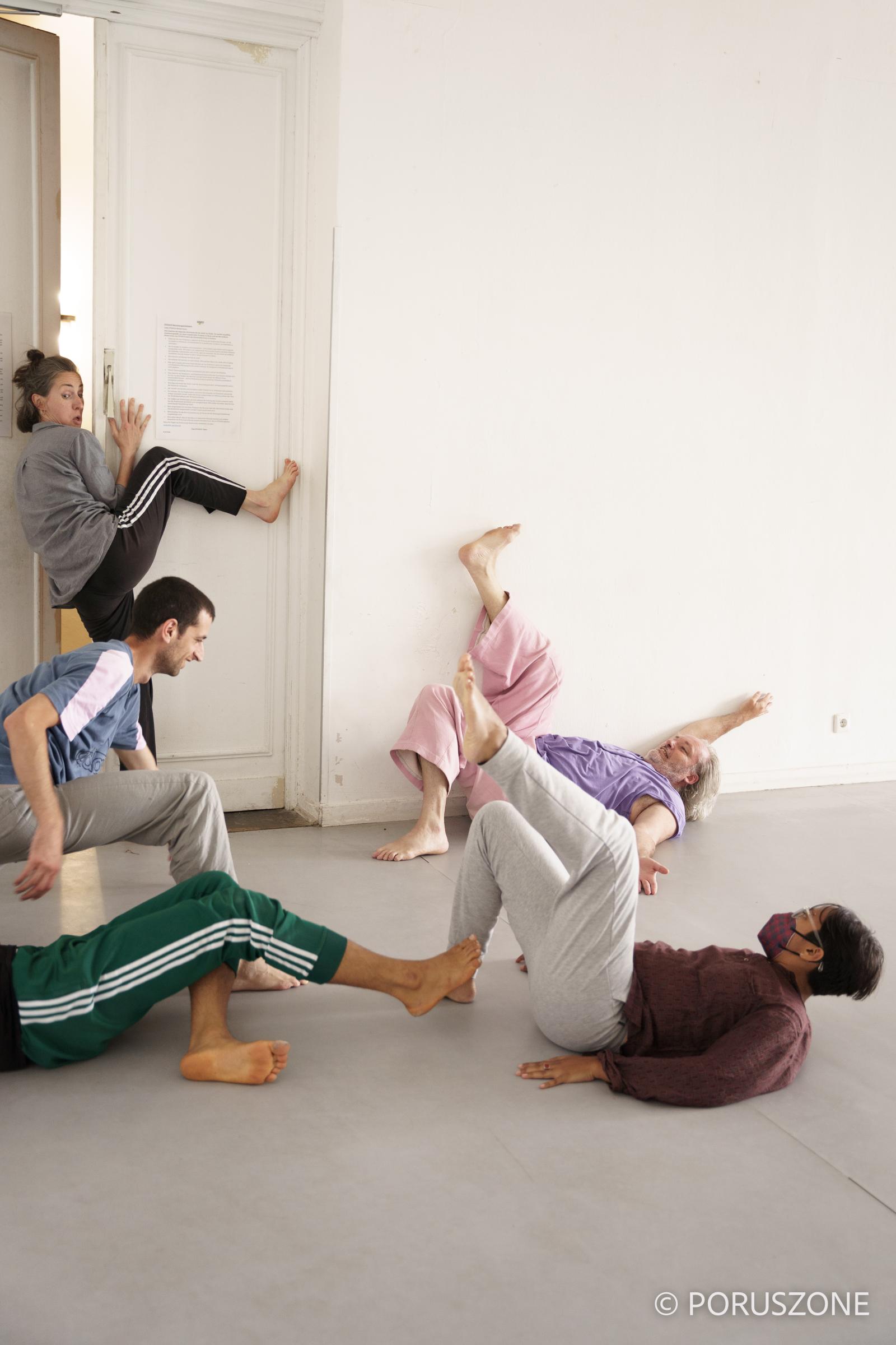 A group of dancers in various poses on the ground.