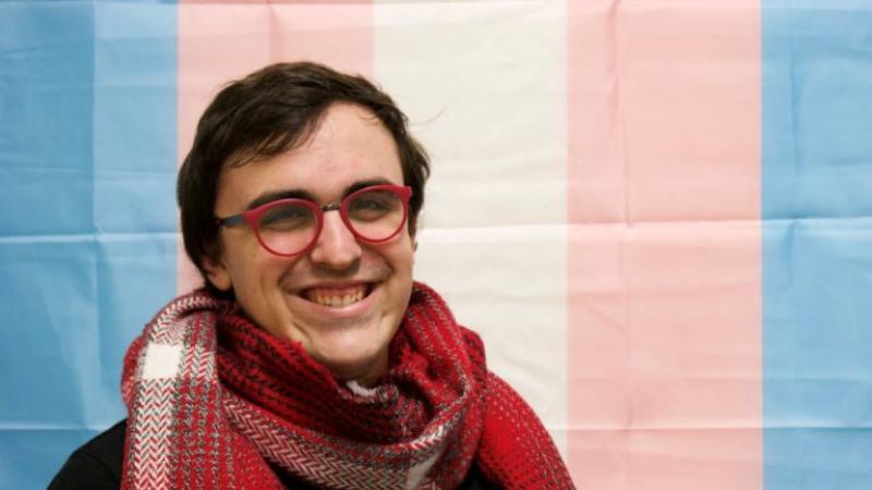 Sterling Ambrosius, wearing a red scarf, smiles at the camera.