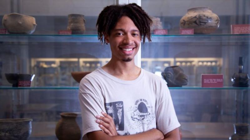 Terrence Freeman stands in front of a pottery display and smiles at the camera.