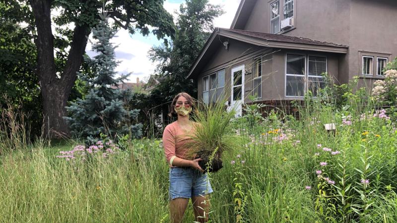 Bronwyn Earthman ’21 holding a plant in a field 