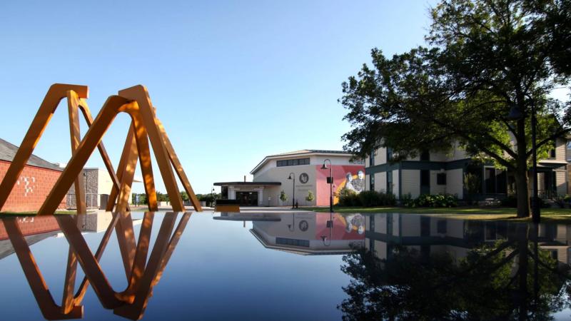 Aerial Landscape sculpture, the Wellness Center, and Sampson House reflected just before sunset.