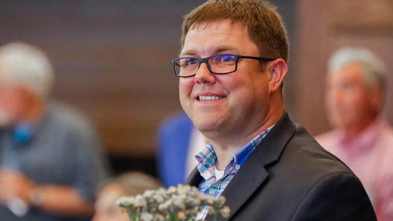 Will Piper holds flowers at an event. 