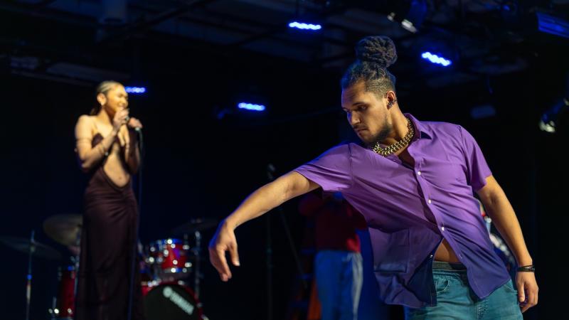 A student dances on stage during a song.