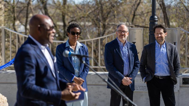 Board of Trustees Chair Cory Nettles speaks at the walkway dedication as President Laurie A. Carter, Mark Burstein, and David Calle look on.