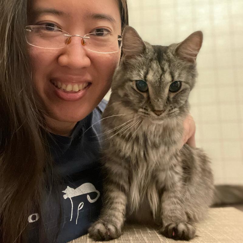 Casual headshot of Alvina Tan with a small gray cat.