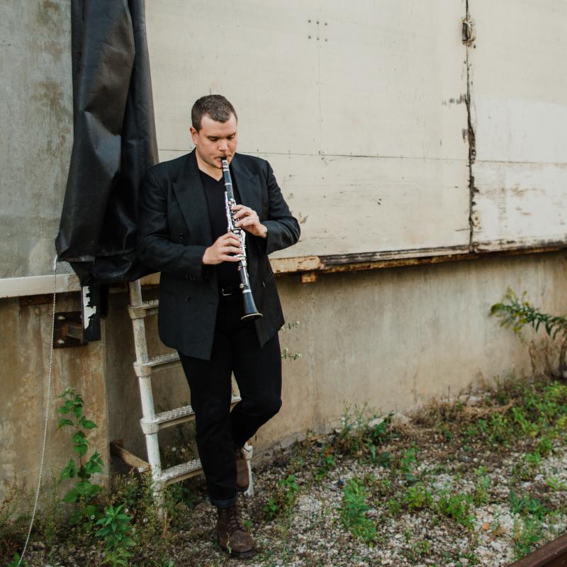 Clarinetist Andy Hudson plays his clarinet outside.