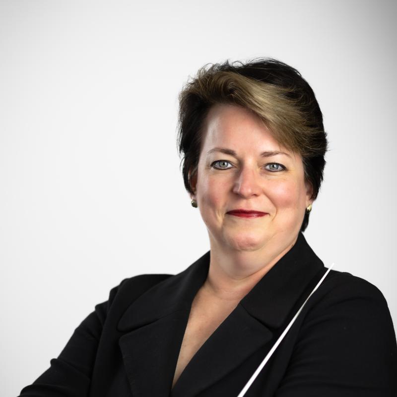 Kristin Roach holding a baton wearing a black jacket.