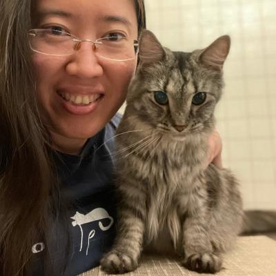 Casual headshot of Alvina Tan with a small gray cat.