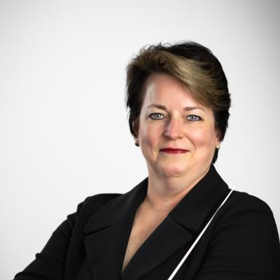 Kristin Roach holding a baton wearing a black jacket.