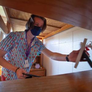 New student putting away items on a shelf in a dorm.