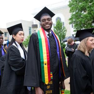 Graduating Lawrentian stands in line, smiling.