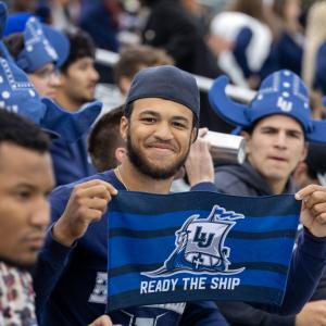 A student holds a Ready the Ship towel at Banta Bowl.