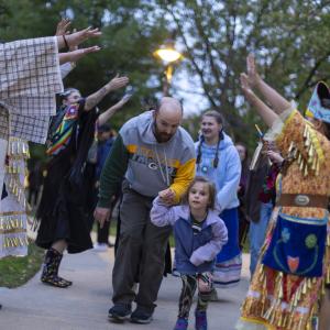 Participants walk through Main Hall Green as part of the Indigenous Peoples' Day Celebration.