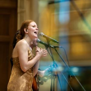 Lawrence Memorial Chapel’s stained glass is reflected in a window while Buffalo Rose performs during Mile of Music. 