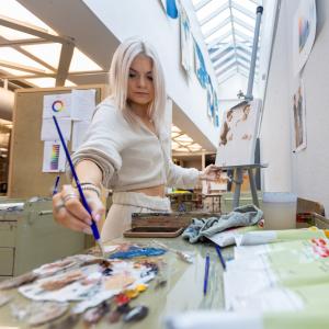 Berkeley Krell paints during a class in Wriston Art Center.